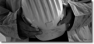 un operaio tiene tra le mani un casco di sicurezza